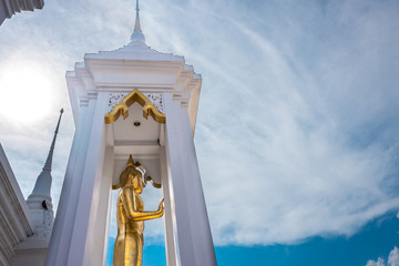 Buddha statue stand in front of Thai temple
