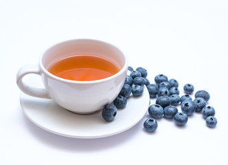 Mug of tea with blueberries on a light background