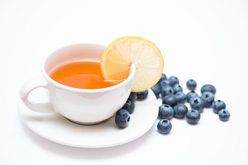 Mug of tea with blueberries on a light background