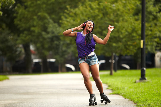 Young woman rollerskating and listening to music