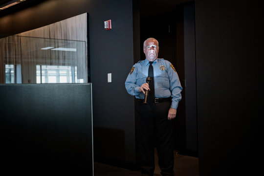 Security guard illuminating face with torch