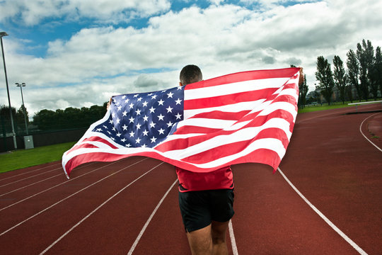 Sprinter running with US flag on sportstrack