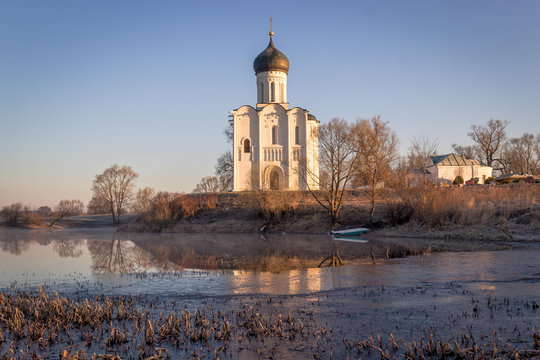 View to the Church of the Intercession of the Holy Virgin on the Nerl River in sunlight.