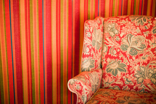 Floral patterned chair against striped wall