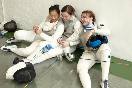 Female fencers sitting together
