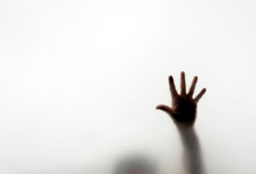 Man pressing hand against window