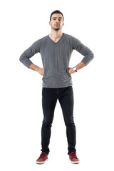Suspicious distrustful man with hands on hips looking at camera. Full body length portrait isolated over white studio background.