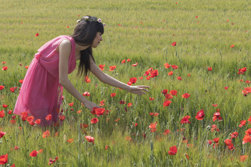 Mujer joven  y feliz en un campo de amapolas