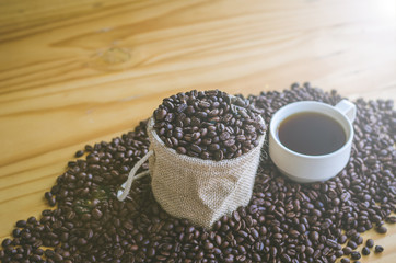 Coffee cup with coffee beans on wood table