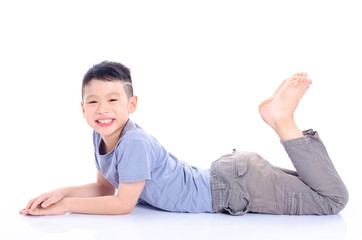 Young asian boy lying down on the floor over white