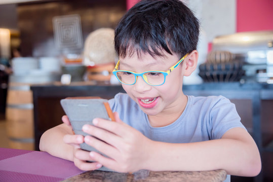 Young Asian Boy Playing Games On Smart Phone