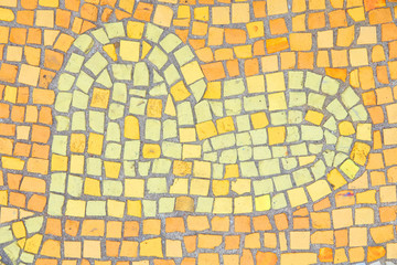 Beautiful background of multi-colored tiles. Tiled mosaic in pastel colors in the form of a heart. Brown, yellow, orange