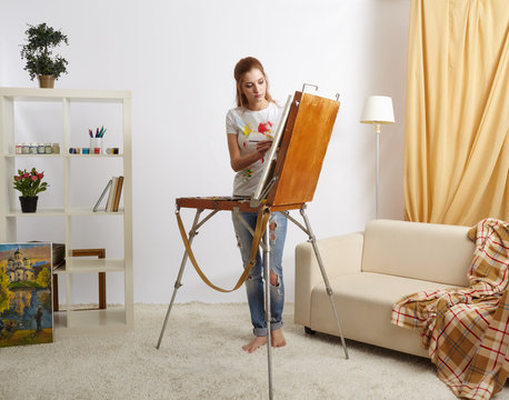 Painter female with wooden sketchbook and painting