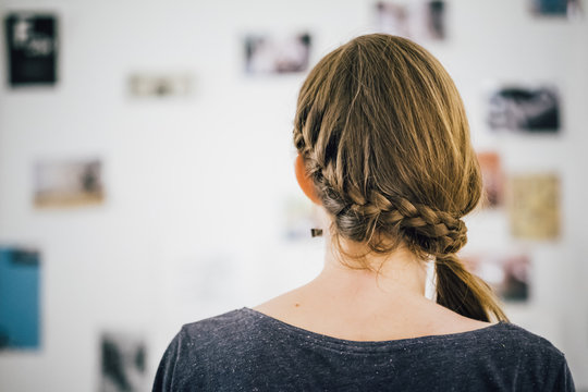 junge Frau vor Bilderwand