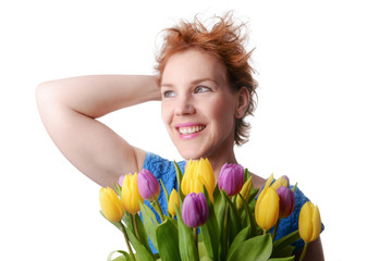 Beautiful woman in the blue dress with flowers tulips in hands on a light background