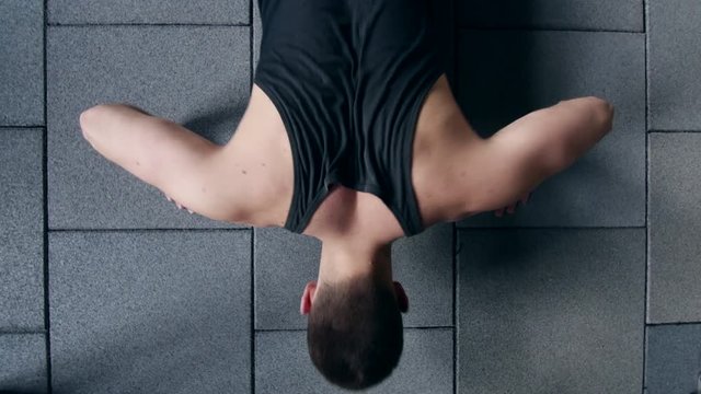 Sportsman exercising in the gym. Muscular young man doing pushups on exercise mat.