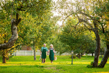 Couple of elderly gardeners walking. Woman and man, summer nature.