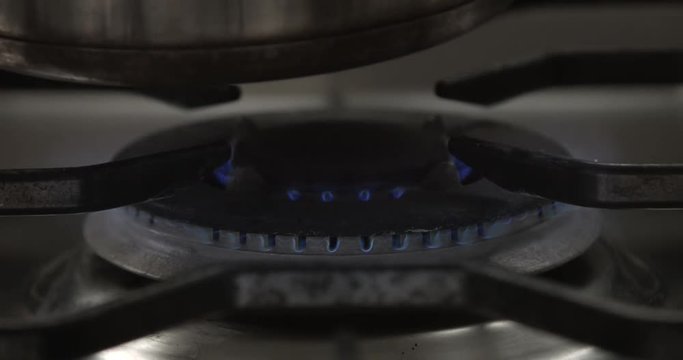 Close focus on big central gas hob and a pan put on it