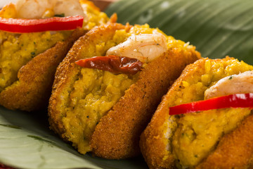 Acaraje - Traditional Brazilian fritters made with black-eyed peas filled with vatapa, caruru, tomato salad and sauteed shrimp. Typical food from Bahia.
