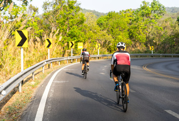 Asian men are cycling road bike morning uphill on the road