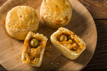 Empada Brazilian snack. pie with shrimp on wood plate on wooden background