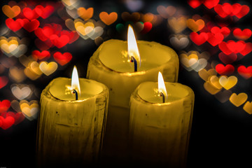 Three candle flame at night with heart bokeh select focus