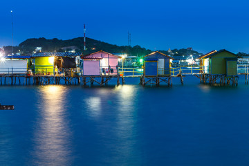 Fototapeta na wymiar wooden house on the sea at night with color light