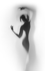 Diffuse silhouette of a beautiful dancer woman behind a curtain