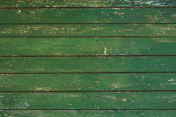 Green wooden texture background. Closeup of weathered painted wood planks of old house or barn....