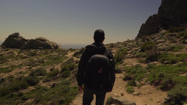 Tracking shot of man hiking in the mountains