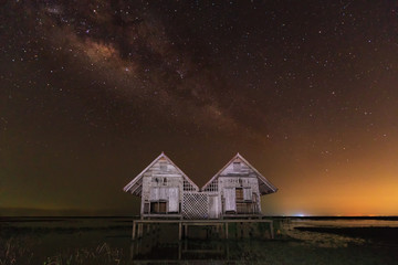 The milky way landscape with abandoned hut on field in Thailand