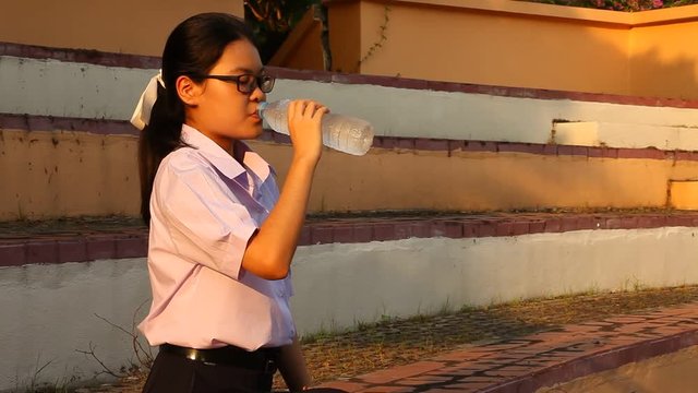Thai student girl drinking water