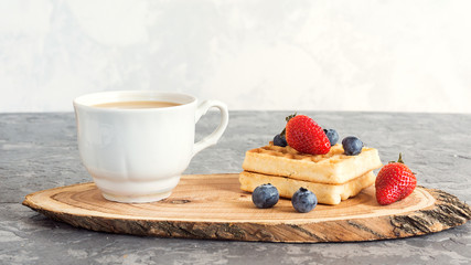 Coffee break with cup of coffee, fresh Viennese waffles and fresh berries