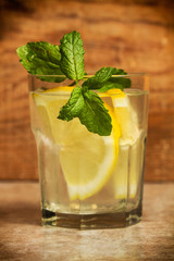 Limonada en vaso con hierbabuena sobre mesa rústica. Vista de frente. Primer plano