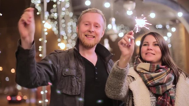 Couple with sparklers on the background of night city