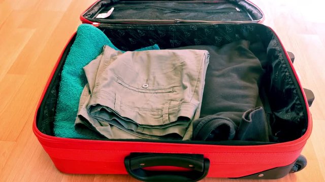 Young guy are packing suitcase for a journey. Dreams about travel.