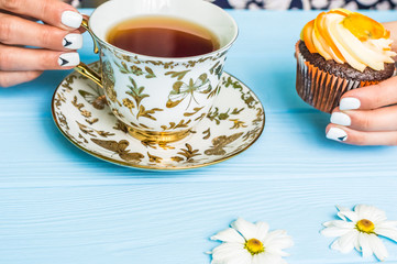 Still life with cup of tea and cake on the wooden background