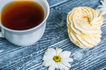 Still life with cup of tea and cake on the wooden background
