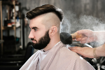 Hairdresser man shaves a client with a beard in a barbershop