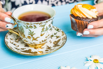 Still life with cup of tea and cake on the wooden background