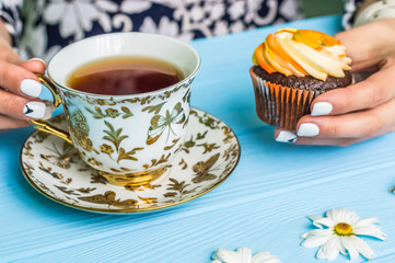 Still life with cup of tea and cake on the wooden background