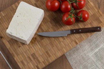 tomatoes and cheese on wooden cutting board top view