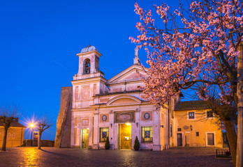 Church and Shrine of the Mother of Divine Love (Madonna del Divino Amore) outside Rome, Italy, at blue hour with spring blossom trees.