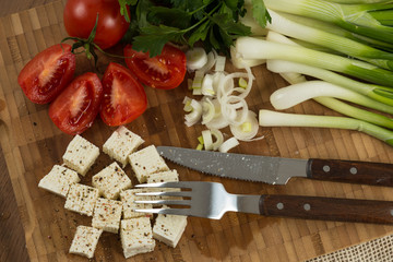 organic cheese cubes and tomatoes on wooden table top view