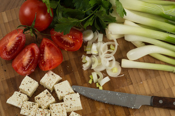 organic cheese cubes and tomatoes on wooden table top view