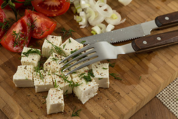 organic cheese and tomatoes on wooden cutting board