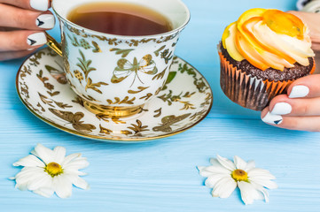 Still life with cup of tea and cake on the wooden background