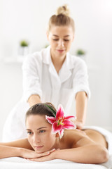 Obraz na płótnie Canvas Two beautiful women getting massage in spa