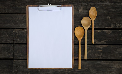 Blank paper clipboard and wooden spoon design over vintage wood background
