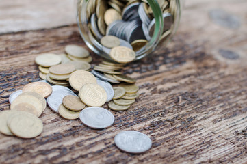 Ukrainian coins in glass jar on a wooden background